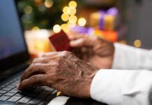 Hands using a laptop and holding a credit card