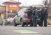 A Double Murder’s Chilling Motive Comes Into Focus Police officers gather beside a patrol SUV at a taped-off scene