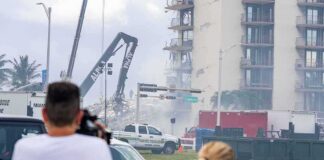 Rescue crews and cranes clear debris at a damaged high-rise building