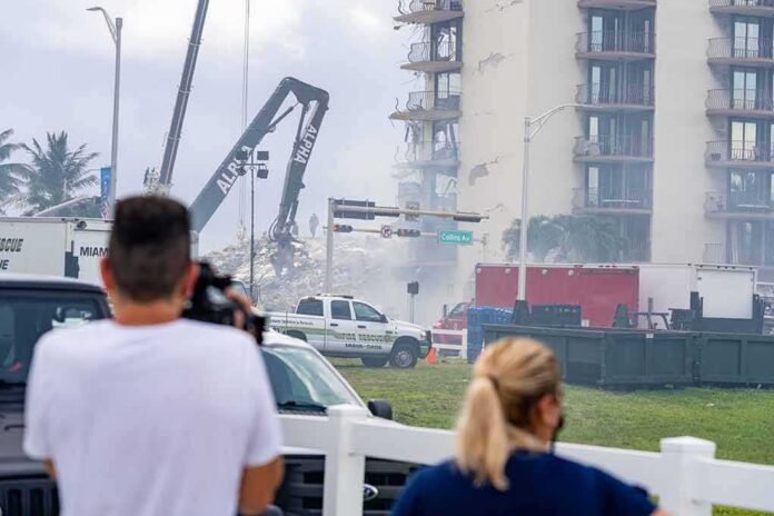 shutterstock_1997657474 Rescue crews and cranes clear debris at a damaged high-rise building