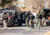 She Gave Him Shelter. Then Came Horror. Police and sheriff officers gather around vehicles on a suburban street