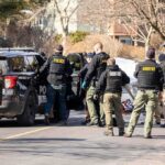 She Gave Him Shelter. Then Came Horror. Police and sheriff officers gather around vehicles on a suburban street