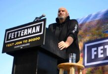 Children’s Hospital Brushed Off—Why? Speaker at outdoor rally standing at podium with microphone