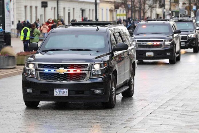 black SUVs with flashing lights driving in a motorcade