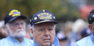 Elderly veteran in blue jacket and cap at a ceremony
