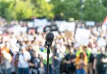 MacArthur Park MELTDOWN After Bieber Drop-In Microphone on a stand facing a large blurred crowd