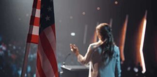 American flag and speaker at podium addressing audience