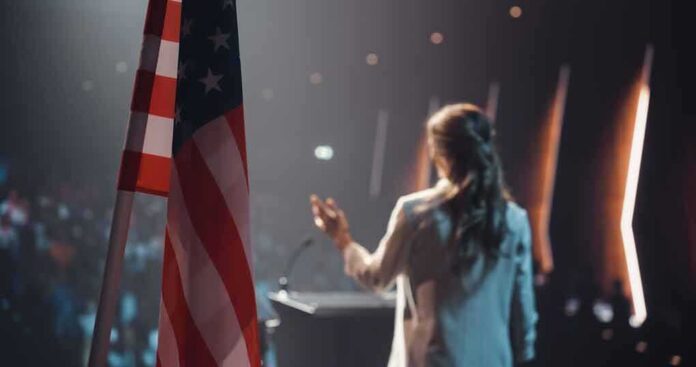 American flag and speaker at podium addressing audience