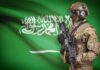 Holy City Target? Saudi Sounds Red Line Alarm Soldier in tactical gear stands before a green flag