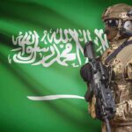 Holy City Target? Saudi Sounds Red Line Alarm Soldier in tactical gear stands before a green flag