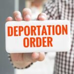 Appeals Court Cripples Fast Deportations Hand holding a card with bold red text