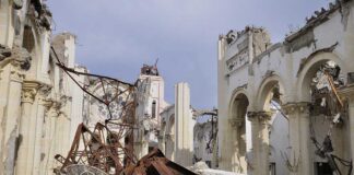 Interior view of a destroyed building with collapsed arches and debris