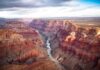 Helicopters Race In As Grand Canyon Floods Grand Canyon with river winding through layered red cliffs