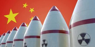 Row of nuclear missiles with radiation symbols before a red flag with yellow stars