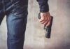 person holding a handgun by their side