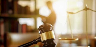 Judge's gavel on a desk with scales of justice in background