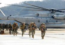 After Two Decades, America’s Mission Takes a Turn Soldiers disembark and walk past a large military helicopter