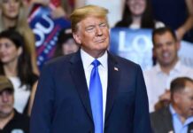 Nuclear Ultimatum: Trump Stares Down Iran Donald Trump at a rally wearing a dark suit and blue tie
