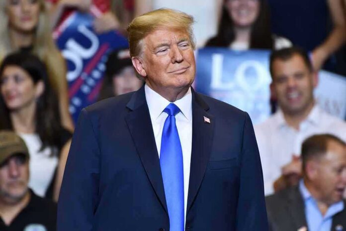Donald Trump at a rally wearing a dark suit and blue tie