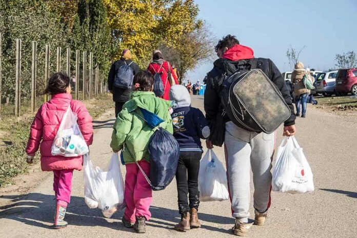 Group of people walking along a road carrying bags