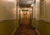 empty hotel hallway with patterned carpet and closed doors