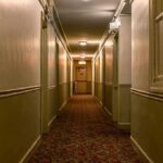 empty hotel hallway with patterned carpet and closed doors