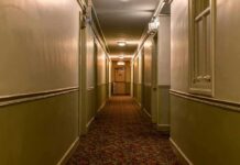Poconos Horror Inside One Hotel Room empty hotel hallway with patterned carpet and closed doors