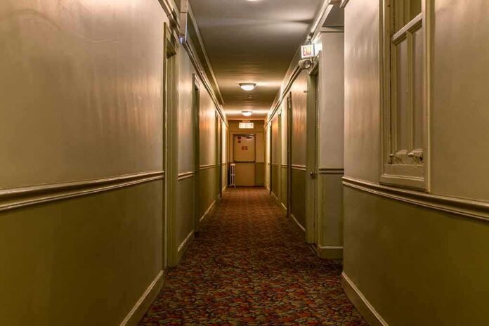 empty hotel hallway with patterned carpet and closed doors