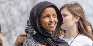 Ilhan Omar wearing a black headscarf at an outdoor event