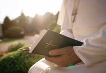 The Vatican Faces an Unexpected Medical Week Person in white robe holding a Bible outdoors