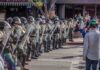 A Country Concert Ends Before It Begins Riot police in helmets and shields form a line on a city street