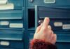 A New Federal Rollout Reaches America’s Youngest A hand holding a key, opening a blue mailbox drawer