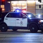 Police SUV blocks an intersection at night with lights flashing