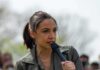 AOC speaking into a handheld microphone outdoors