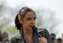Political Reactions Intensify as Campus Case Reopens AOC speaking into a handheld microphone outdoors