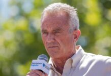 Senator’s Line Sparks RFK Jr. Firestorm Man speaking into a microphone outdoors