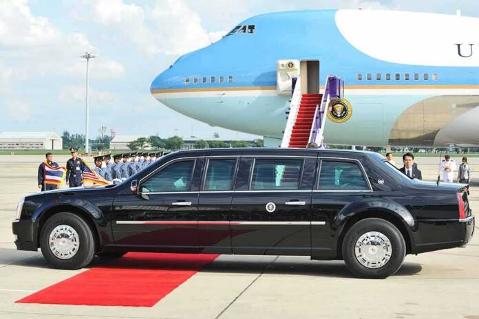 Presidential limousine beside a large blue-and-white jet on a runway