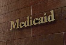 A Leaked Report, a Courtroom Twist, and Millions Medicaid sign on a brown wooden wall