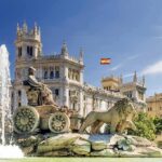 Cibeles Fountain with lions before ornate palace building