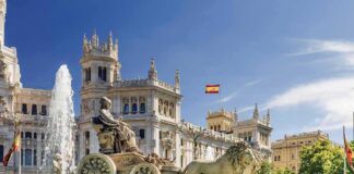 Cibeles Fountain with lions before ornate palace building